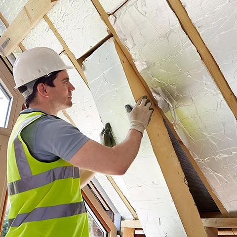 Construction worker weatherizing a structure